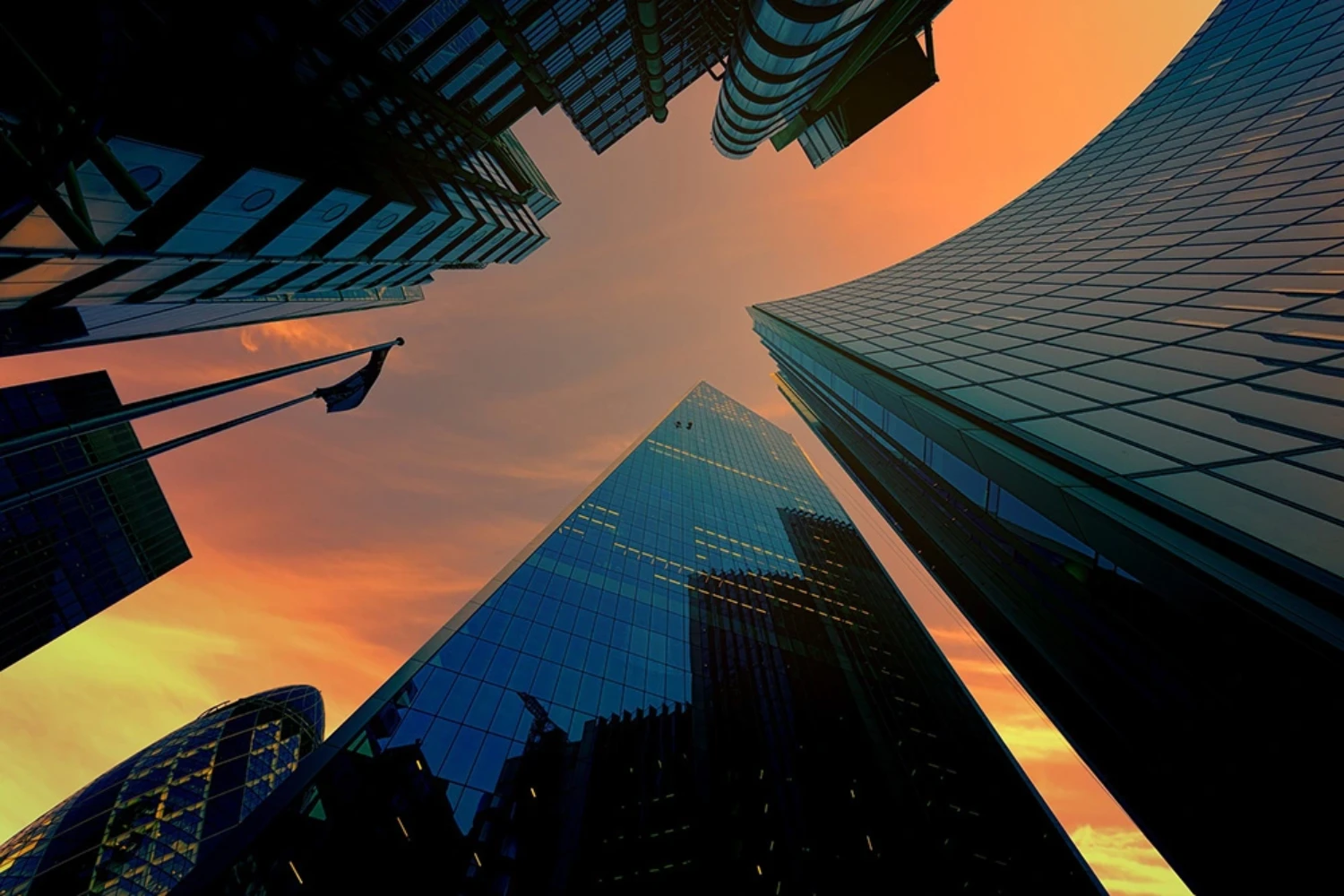 Low angle view of buildings at sunset, when the sky is orange