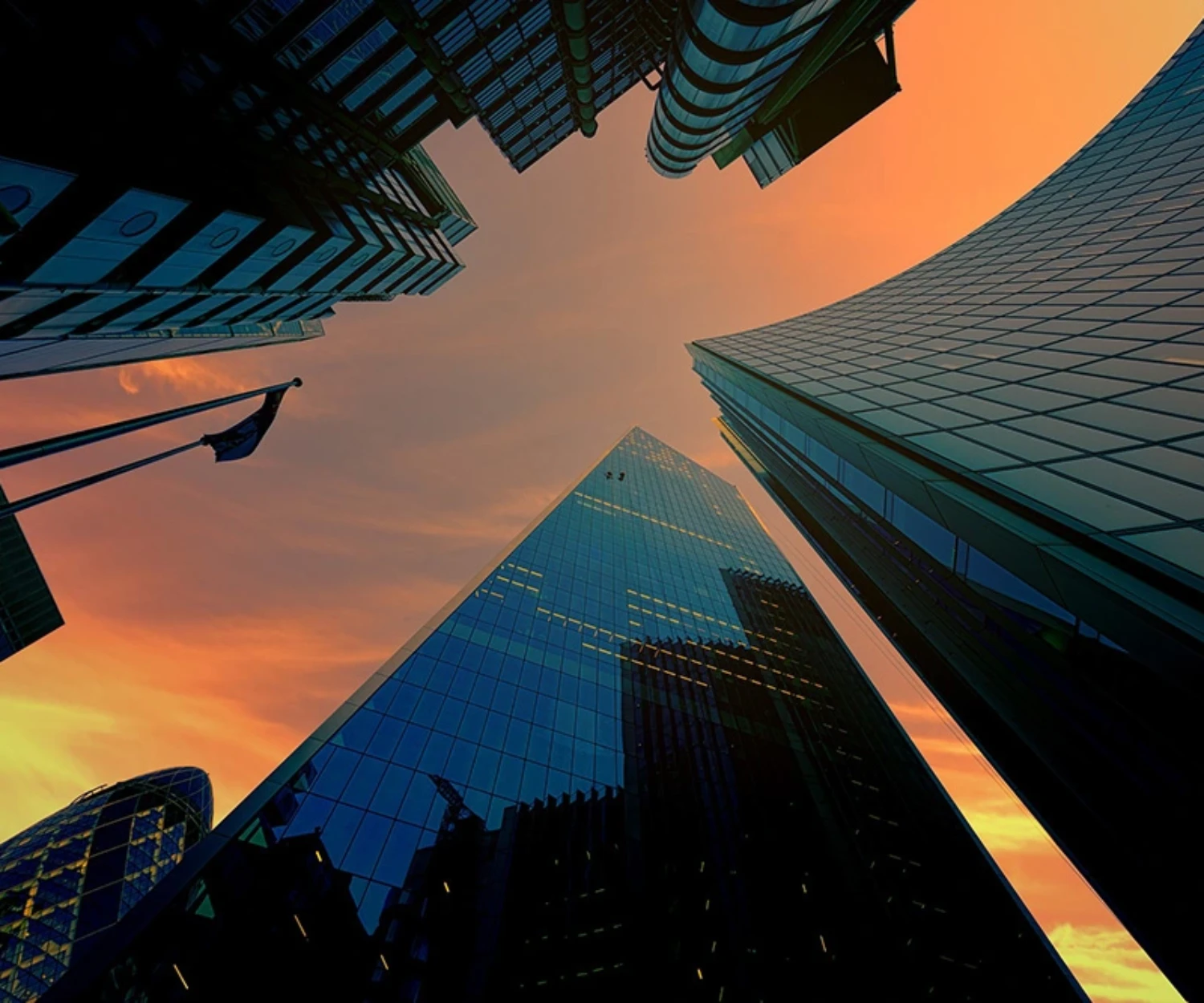 Low angle view of buildings at sunset, when the sky is orange